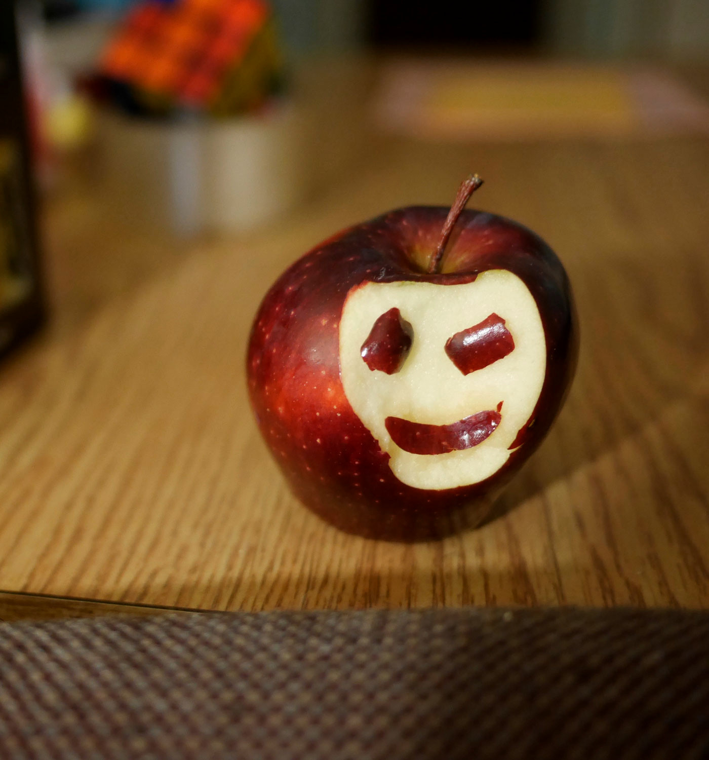 Photo of an apple with a smiley face.